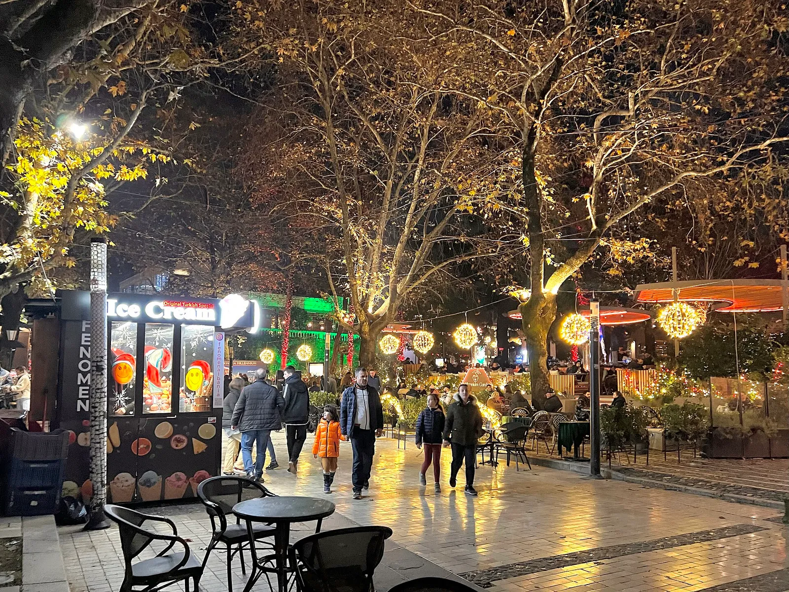 רחוב הולכי רגל בטירנה בערב, אנשים מטיילים בג'ירו בין בתי קפה ואורות