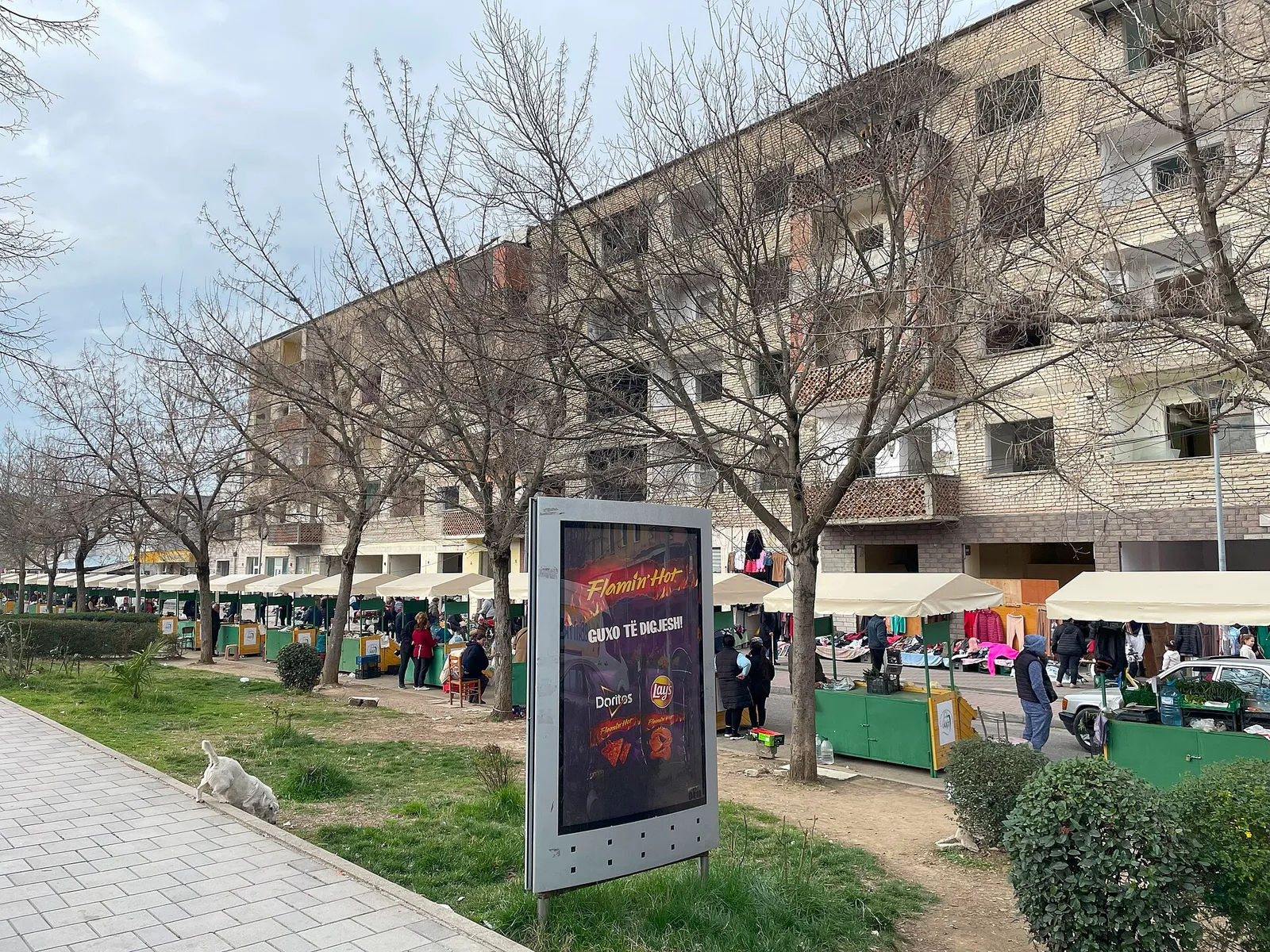 שוק פשפשים תחת גוש מגורים בטירנה, דוכני בגדים ומציאות יד שנייה