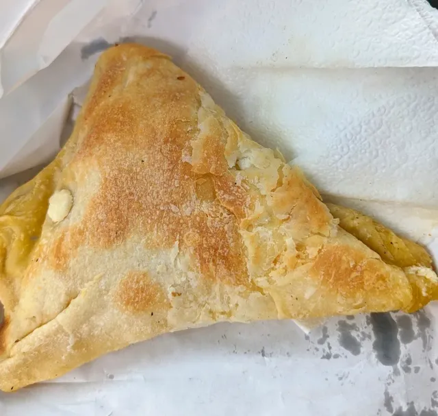 משולש בצק עלים אפוי ומבריק מונח על מפית נייר לבנה