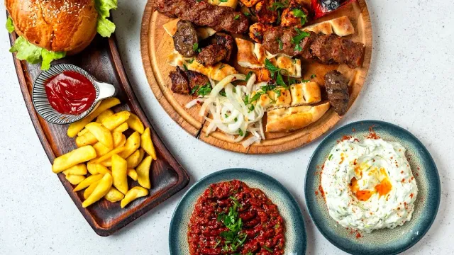 מגש שיפודי בשר עם לאפה ובצל, המבורגר, צ׳יפס ומטבלים אדום ולבן
