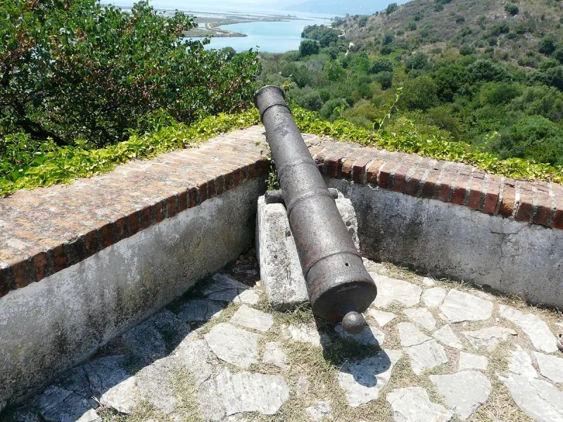 תותח עתיק על חומת מצודה מעל תעלת מים
